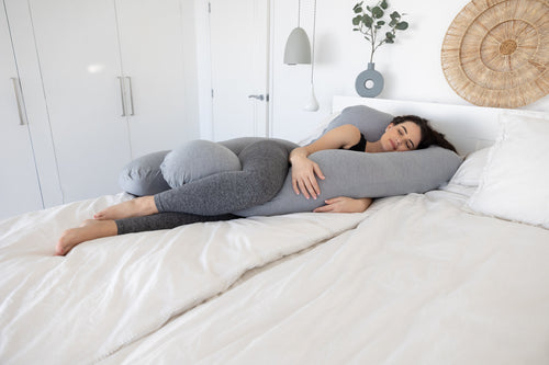 vrouw slaapt op zwangerschapskussen