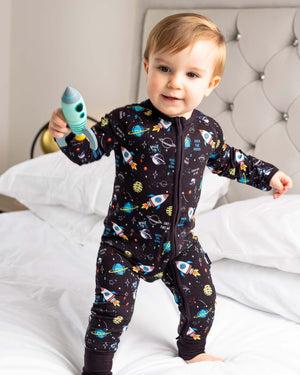 toddler with rocket on bed