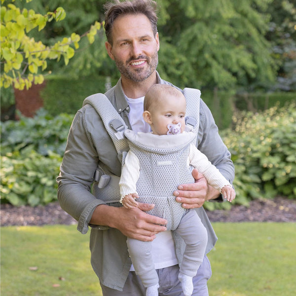 Dad with a baby facing out in the grey AirMesh carrier