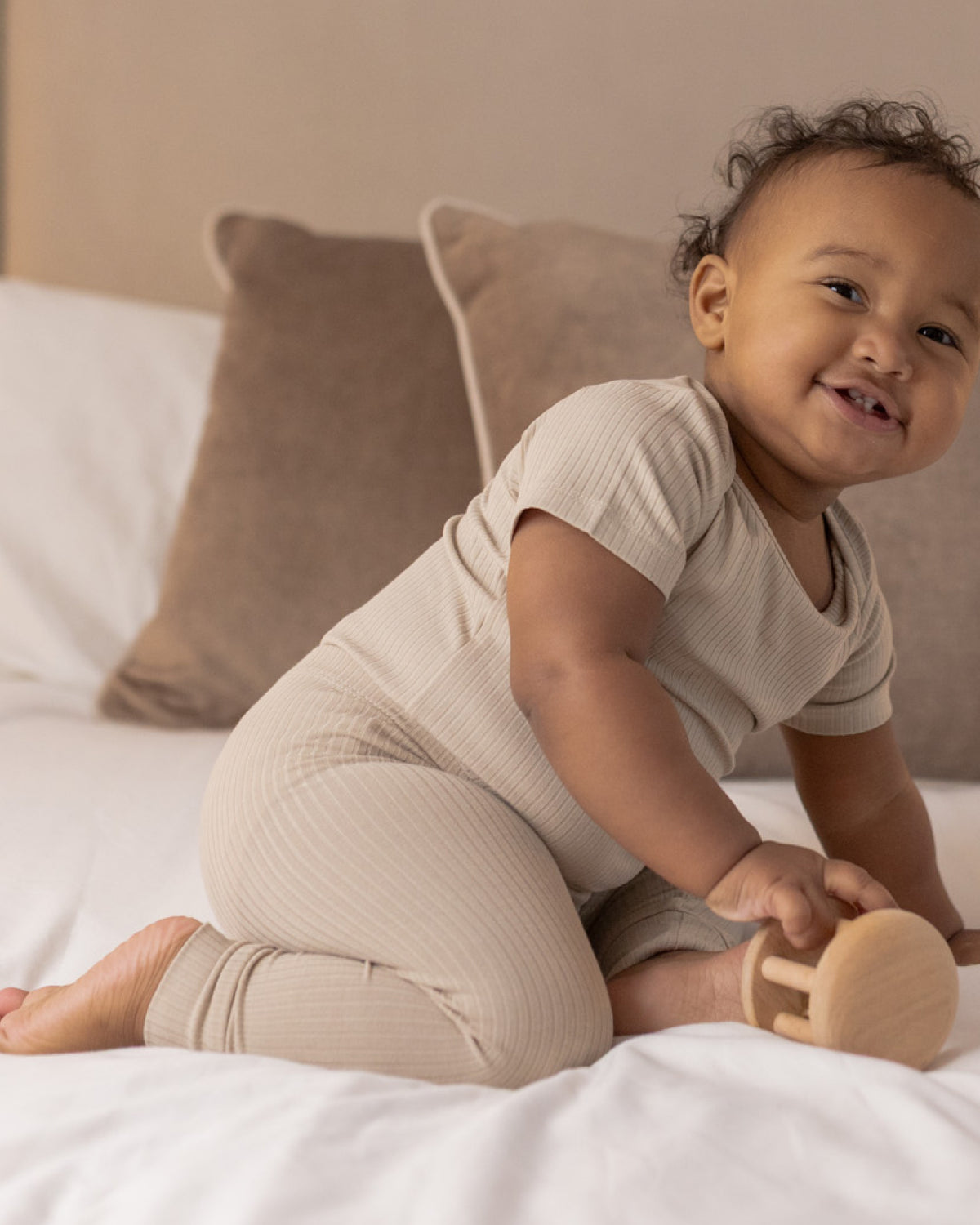 Baby sitting in oatmeal ribbed leggings