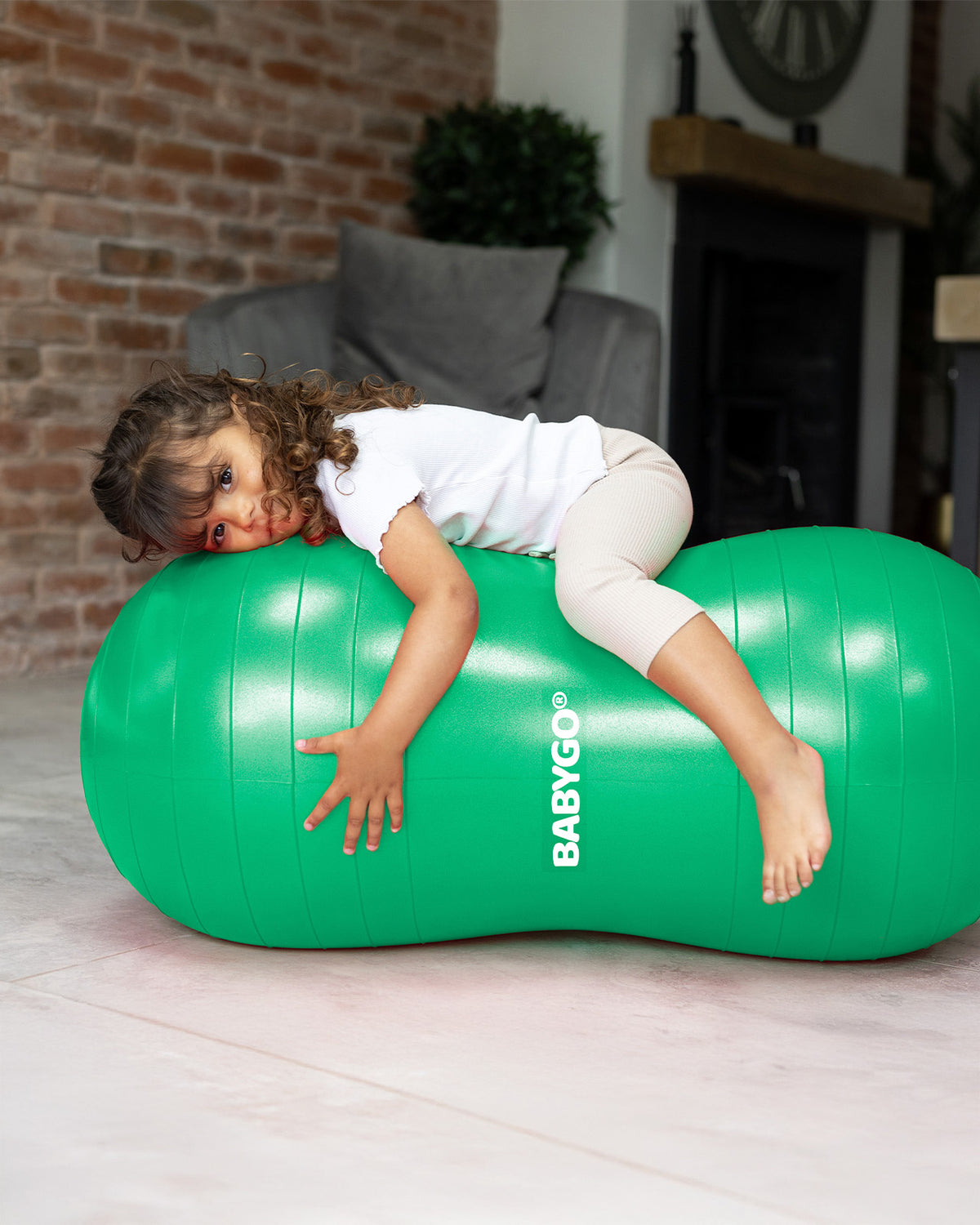 child lying on sensory peanut ball