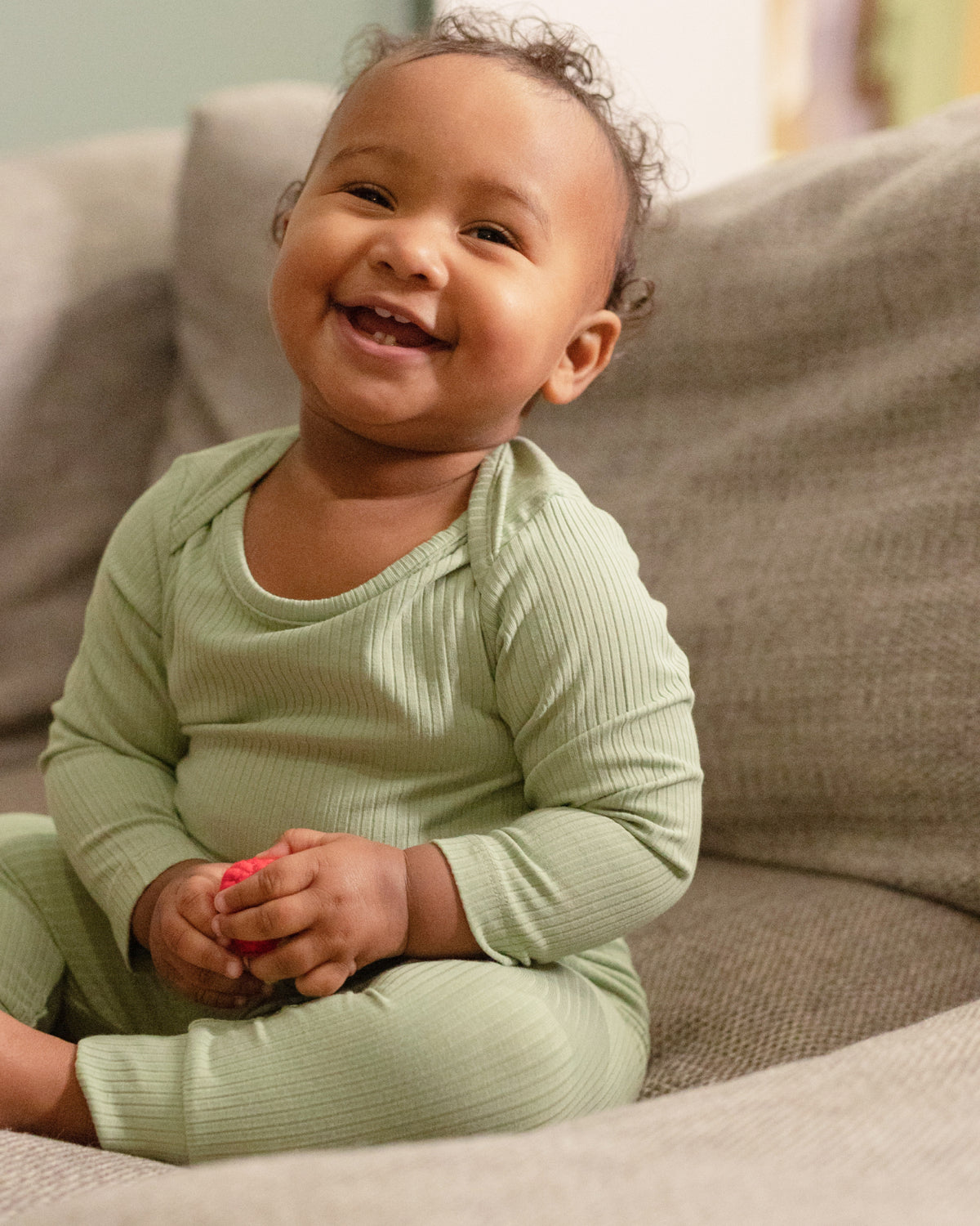 Baby playing in a sage long sleeve bodysuit