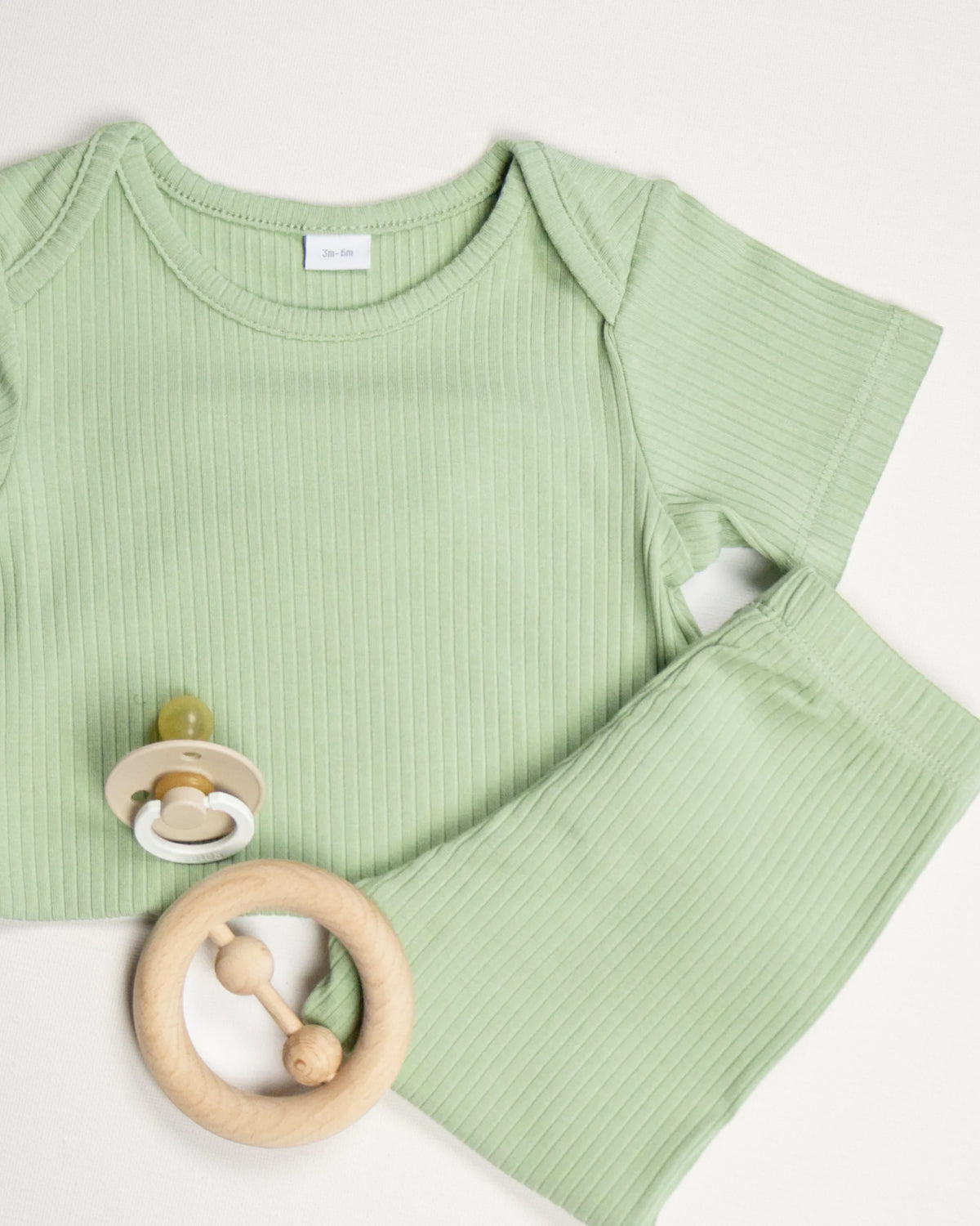Baby wearing a sage ribbed short sleeve bodysuit and leggings set, view 7